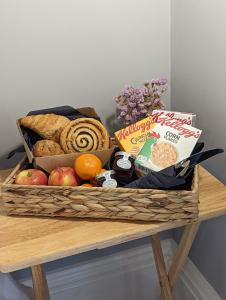 a basket of bread and fruit on a table at Banks Rooms - Minster, Isle of Sheppey in Minster +16 photos