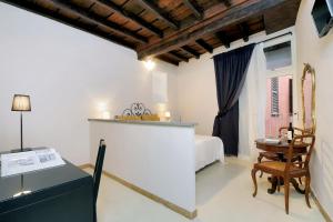 a bedroom with a bed and a table and a chair at Residenze Romanae - Sangallo Rooms in Rome