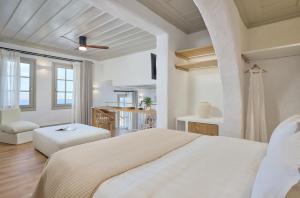 GrandeMar Suites في مدينة أستيباليا: غرفة نوم بيضاء مع سرير وطاولة