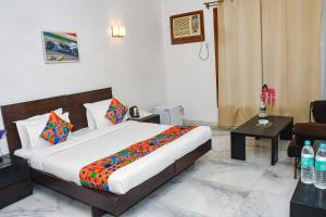 - une chambre avec un lit king-size et une table dans l'établissement FabHotel Premium, à Gurgaon
