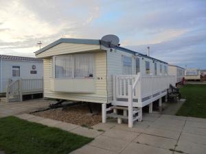 ein gelbes und weißes Mobilheim mit einer Veranda in der Unterkunft 8 Berth on Golden Palm (Florida GP) in Chapel Saint Leonards