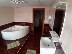 a large bathroom with a tub and a sink at Hotel Turist in Chişinău