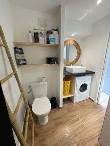 a bathroom with a toilet and a washing machine at Diamond View - Marinotel Vue mer sur le Diamant et accès piscine in Le Diamant