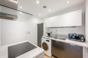 a kitchen with a sink and a washing machine at Modern 1 bedroom flat in the city centre in Birmingham
