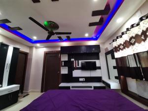 um quarto com uma cama roxa e um tecto com luzes azuis em Soul Homestay em Puri