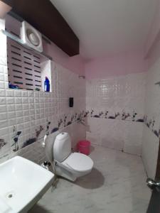 uma casa de banho com um WC branco e um lavatório. em Soul Homestay em Puri