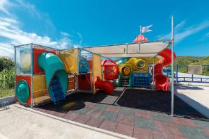 a playground with a slide and a play structure at Villa Lavanda - family friendly, beachfront in Pašman