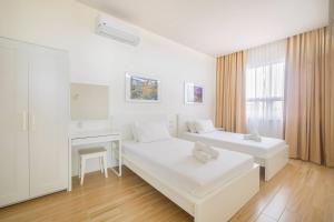 biały pokój z 2 łóżkami i kominkiem w obiekcie Addie's Place Camella Homes 2D Muntinlupa w mieście Manila