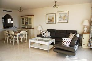 een woonkamer met een bank en een tafel bij Stunning unobstructed 180 degree sea view apartment with 100 square meters terrace - Costa del Sol - Estepona in Estepona