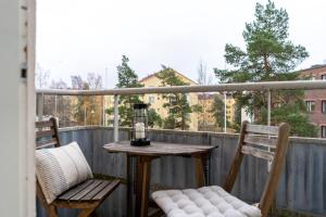 uma mesa e duas cadeiras numa varanda em 1br apartment with patio in Lauttasaari em Helsinque