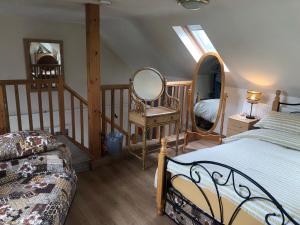 1 dormitorio con cama, espejo y escalera en Lake view Romantic retreat, en Aberystwyth