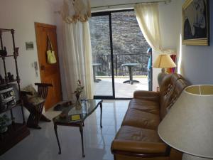 a living room with a couch and a table at Seafront Penthouse with Terrace in Xlendi, Gozo in Xlendi