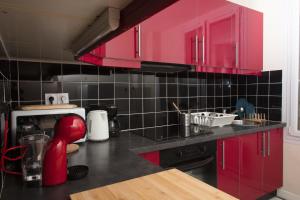 a kitchen with red cabinets and a counter top at 350 M de la gare/10min de l'hyper-centre. in Caen