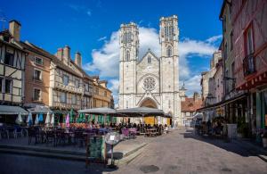 an old church with a clock tower in a street at Le Nid Bourguignon in Chalon-sur-Saône
