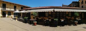 een openluchtrestaurant met tafels, stoelen en parasols bij Hotel Ciocca in Castelnuovo Don Bosco