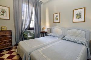 a bedroom with a bed and a dresser and a window at Palazzo Panzani in Florence