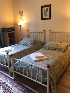 2 camas individuales en un dormitorio con lámpara en Palazzo Panzani, en Florencia
