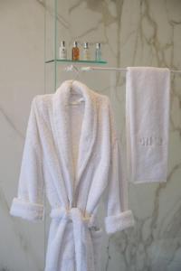 a white robe and towels on a rack in a bathroom at RM The Experience - Small Portuguese Hotels in Setúbal