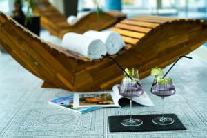 una mesa con dos copas de vino y un barco en Hotel Kristály Konferencia & Wellness, en Ajka