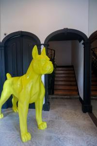 a yellow dog statue in front of a staircase at RM The Experience - Small Portuguese Hotels in Setúbal