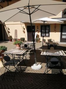 een groep tafels en stoelen met een paraplu bij Hotel Ciocca in Castelnuovo Don Bosco
