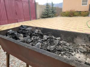 a pile of coal in a barbecue grill at Ай-Ас in Cholpon-Ata