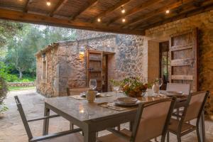 a dining room with a table and chairs and a stone wall at S'Era Nova in Algaida