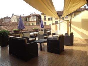 a balcony with chairs and tables and umbrellas at Hotel Ciocca in Castelnuovo Don Bosco