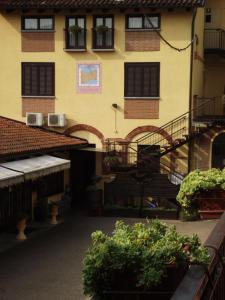 a building with a staircase and plants in a courtyard at Hotel Ciocca in Castelnuovo Don Bosco