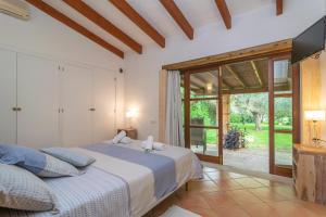 a bedroom with a bed and a large window at S'Era Nova in Algaida