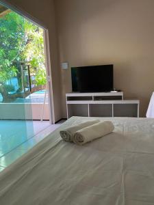 een slaapkamer met een bed met een handdoek erop bij Chalés toca do guaxinim in Itarema