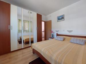 a bedroom with a large bed and a mirror at Apartment Niko in Klenovica