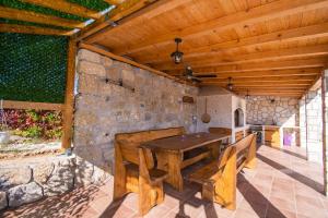 une salle à manger extérieure avec une table et des bancs en bois dans l'établissement Villa Beautiful countryside, à Drniš