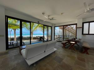 a living room with a white couch and a view of the beach at Mi Playa Beach Front Isabela in Puerto Villamil