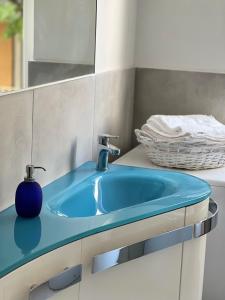 La salle de bains est pourvue d'un lavabo bleu et d'un miroir. dans l'établissement Casa di TAta 2, à Trezzo sullʼAdda