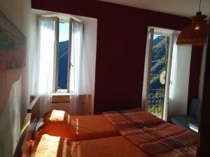 a bedroom with two beds and two windows at Zerba Avventura B&B in Zerba