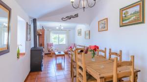 a dining room and living room with a table and chairs at Finca Los Pinos Cómpeta by Ruralidays in Cómpeta