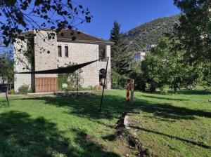 a house with a hammock in front of a yard at 180 mountain lodge in Ioannina
