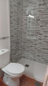 プエルト・デ・モガンにあるLa Caytispaのバスルーム(トイレ、ガラス張りのシャワー付)