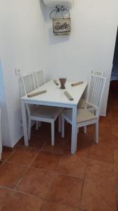 une table blanche avec deux chaises ainsi qu'une table et des chaises blanches dans l'établissement La Caytispa, à Puerto de Mogán