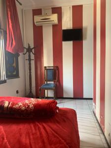 ein Schlafzimmer mit einer rot-weißen gestreiften Wand in der Unterkunft Hotel Sevilla in Chefchaouen