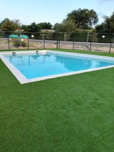 une grande piscine dans un champ d'herbe dans l'établissement Soleil Couchant de Vanessa et Nicolas, à Mimizan