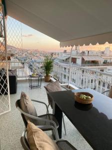 un tavolo e sedie su un balcone con vista di Kolonaki 1 bedroom and 1 Sofabed Amazing Penthouse flat ad Atene