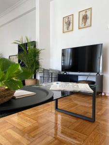 un soggiorno con tavolino e TV di Kolonaki 1 bedroom and 1 Sofabed Amazing Penthouse flat ad Atene