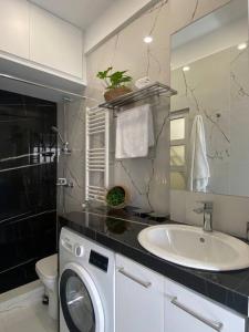 bagno con lavatrice e lavandino di Kolonaki 1 bedroom and 1 Sofabed Amazing Penthouse flat ad Atene