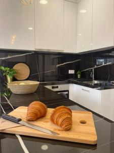 due croissant su un tagliere su un bancone della cucina di Kolonaki 1 bedroom and 1 Sofabed Amazing Penthouse flat ad Atene