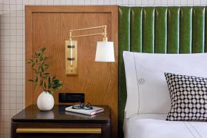 ein Schlafzimmer mit einem Bett und einem Tisch mit einer Lampe in der Unterkunft Omni PGA Resort Frisco-Dallas in Frisco