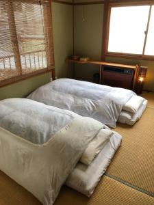 Postel nebo postele na pokoji v ubytování GUEST HOUSE ZU-THONES HAKUBA