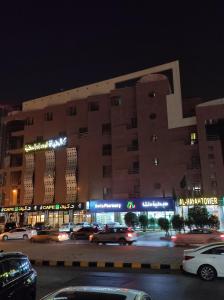 un gran edificio con coches estacionados en un estacionamiento en Burj Al Hayat Furnished Suites - Al Malaz, en Riad