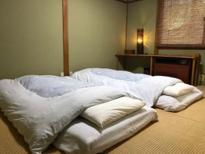 Postel nebo postele na pokoji v ubytování GUEST HOUSE ZU-THONES HAKUBA